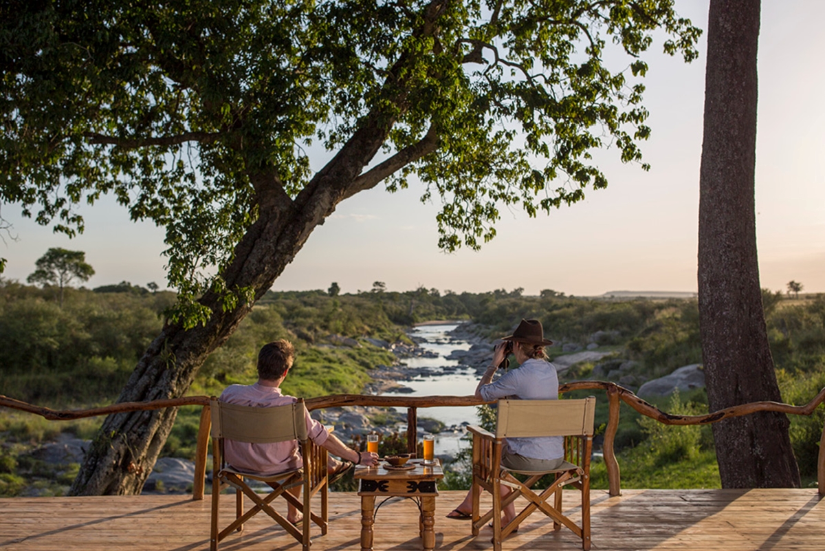 rekero-camp-guests-enjoying-views-from-the-deck Couple enjoying the river views from an elevated wooden deck