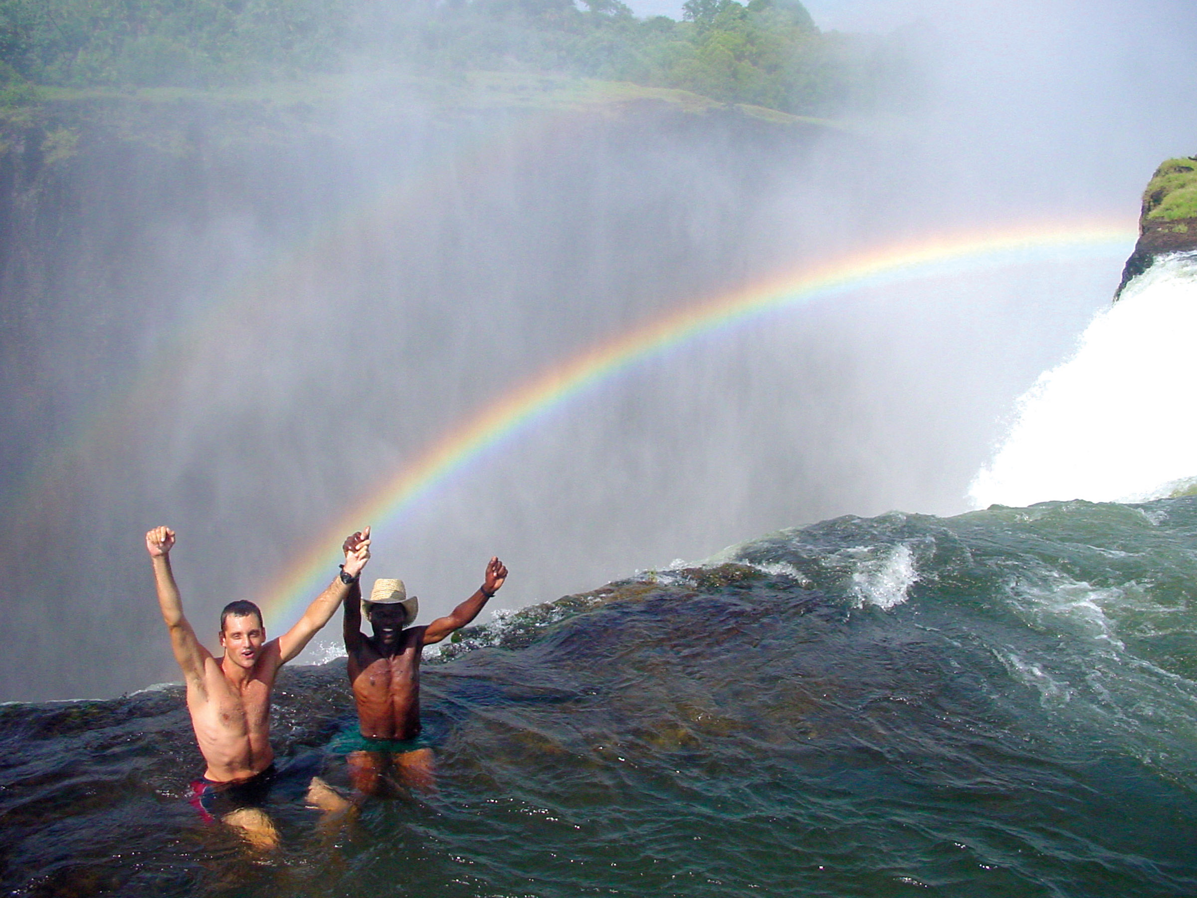 livingstone-island-zambia-devil's-pool Two men swimming in Devil's Pool