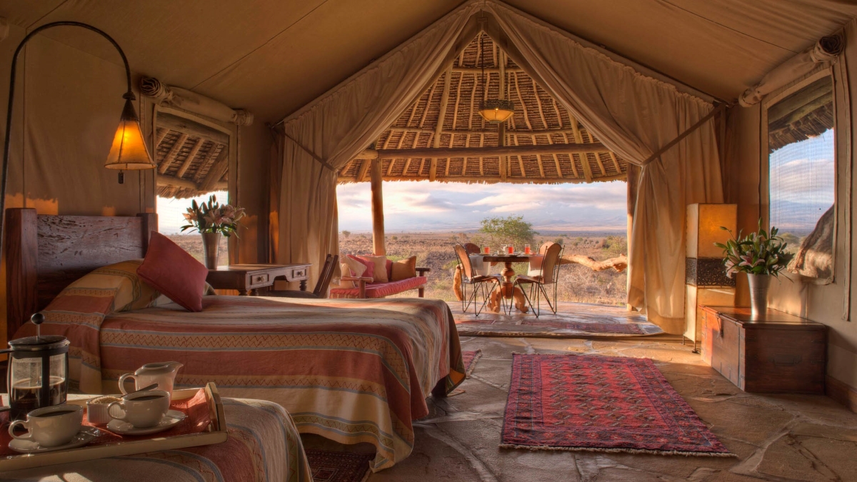 tortilis-camp-bedroom-view Luxury tented suite boasting a grand thatch roof, exquisite stone flooring and plenty of space